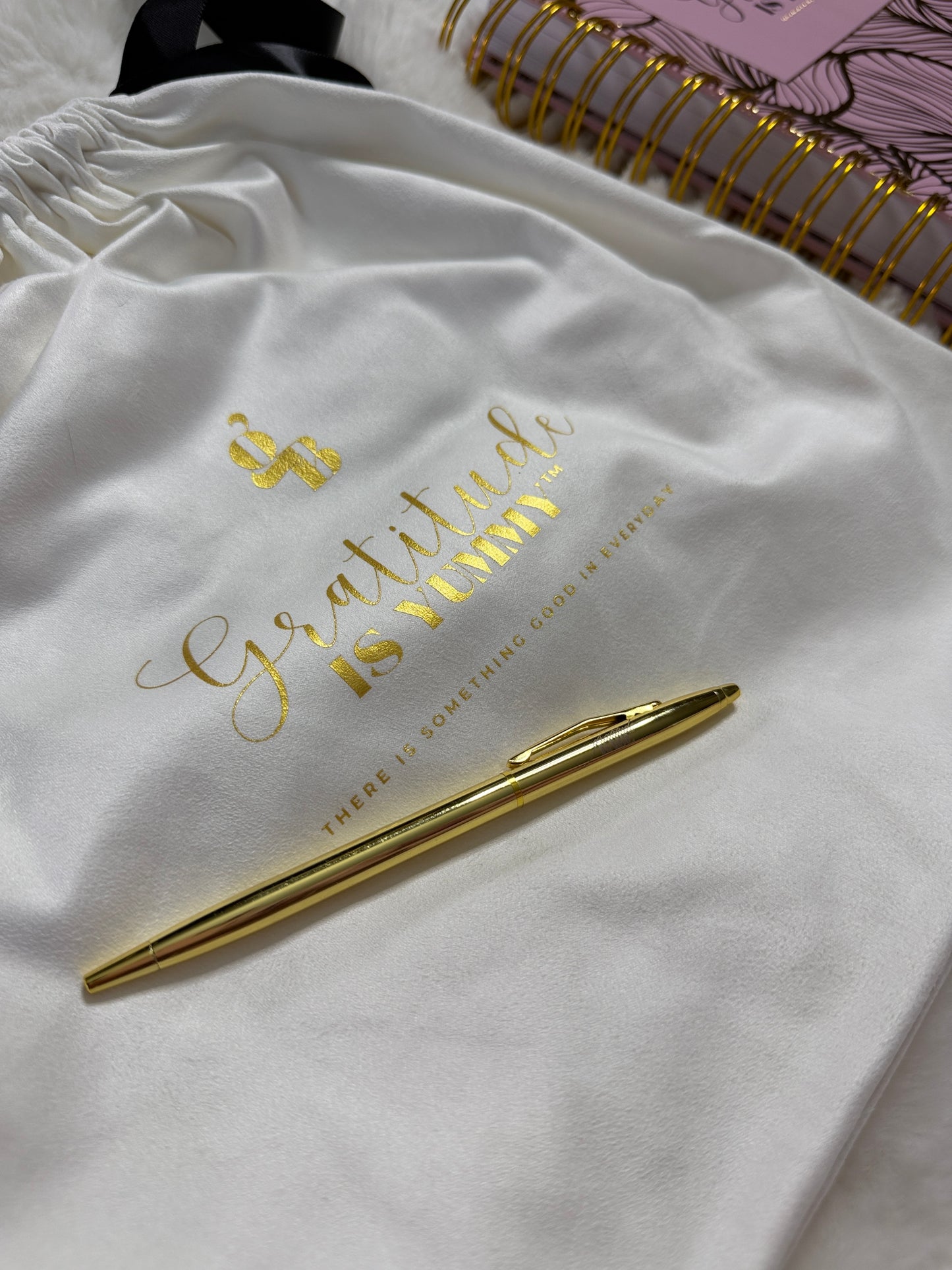 Gold pen on a white surface with 'Gratitude is Virtue' text