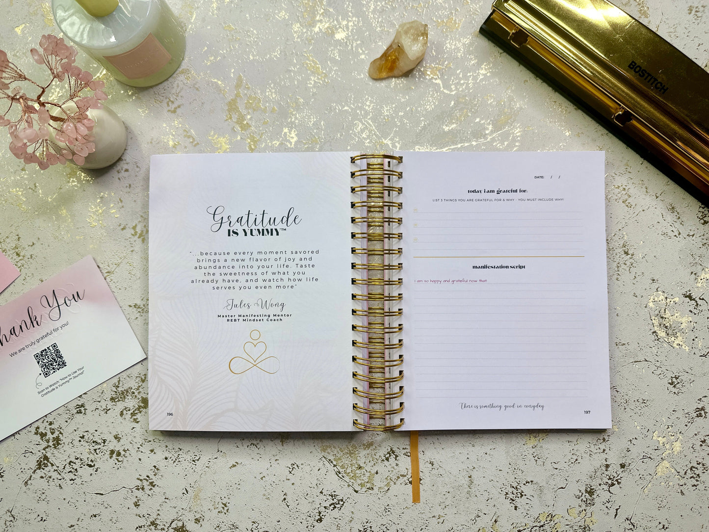 Open notebook on a textured surface with a pen and decorative items.
