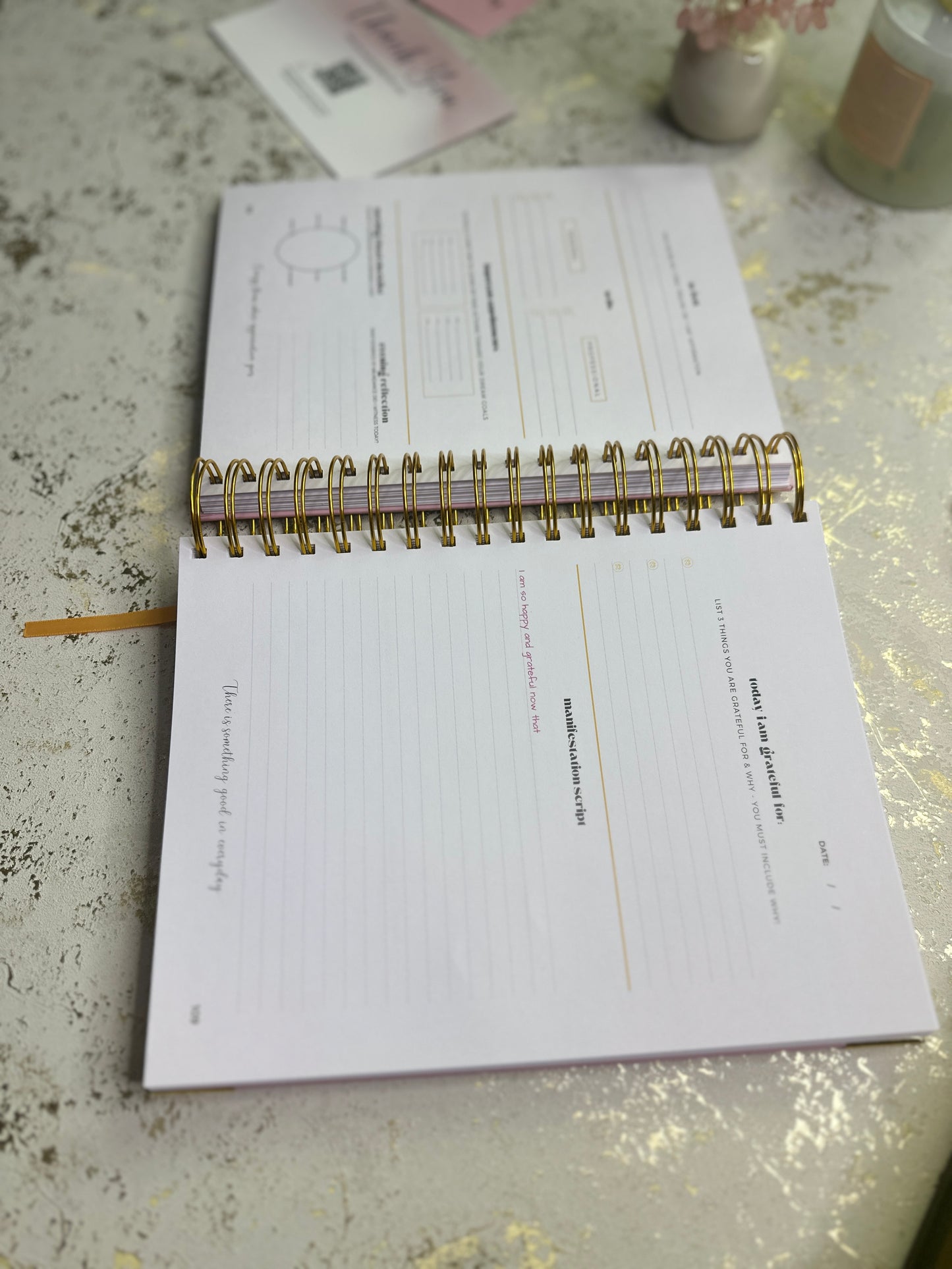 Open notebook on a textured surface with a pen and small items in the background