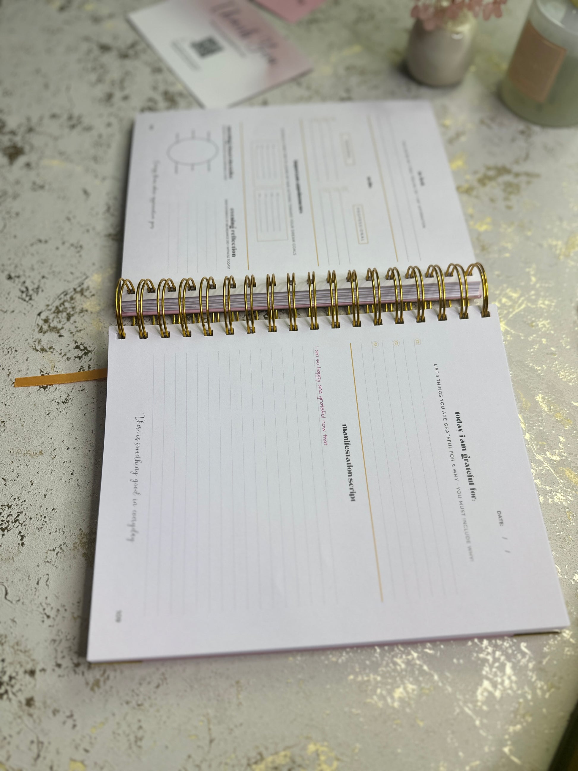 Open notebook on a textured surface with a pen and small items in the background