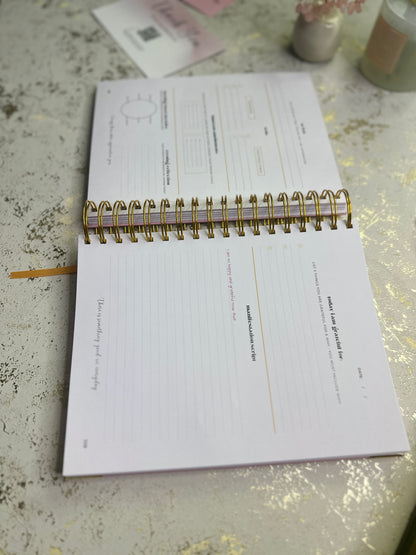 Open notebook on a textured surface with a pen and small items in the background