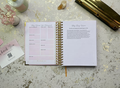 Open spiral-bound planner on a textured surface with stationery items around