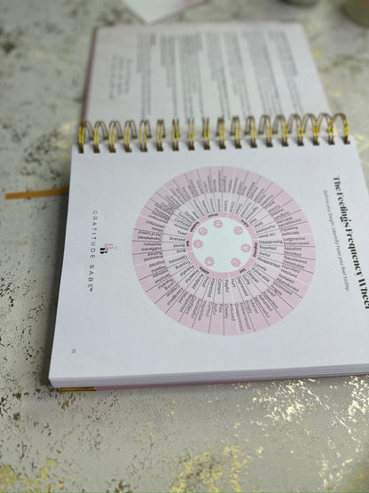 Notebook with a circular design on the cover, placed on a textured surface.